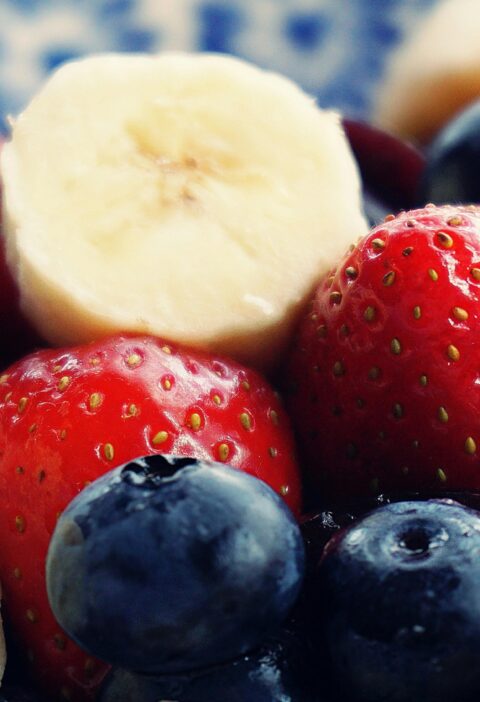 Close-up of fresh bananas, strawberries, and blueberries. Perfect for health and diet themes.