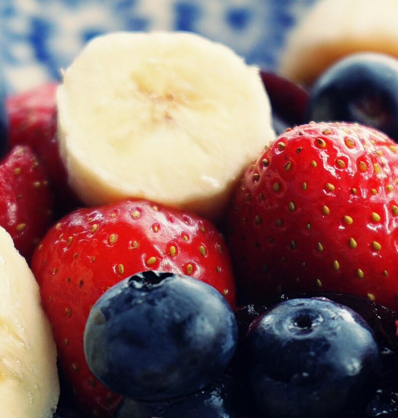 Close-up of fresh bananas, strawberries, and blueberries. Perfect for health and diet themes.