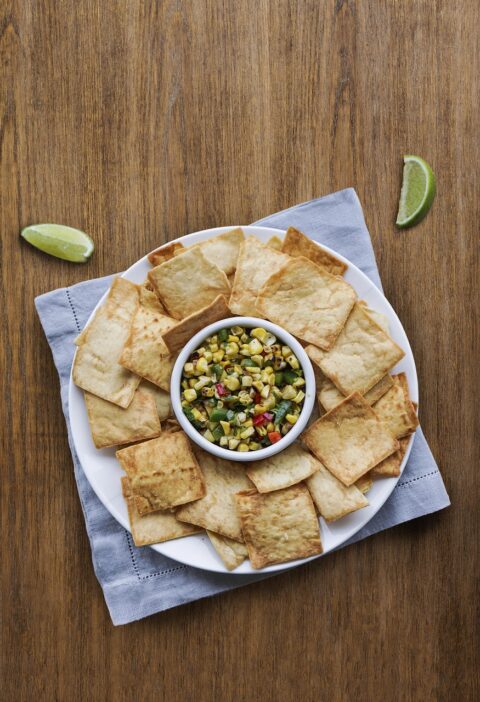 crackers, pita, corn, dip, napkin, bowl, snack, appetizer, lime, crackers, pita, pita, pita, pita, pita, dip