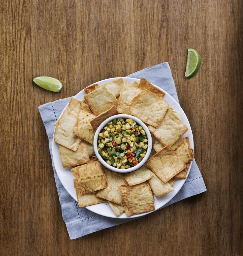 crackers, pita, corn, dip, napkin, bowl, snack, appetizer, lime, crackers, pita, pita, pita, pita, pita, dip