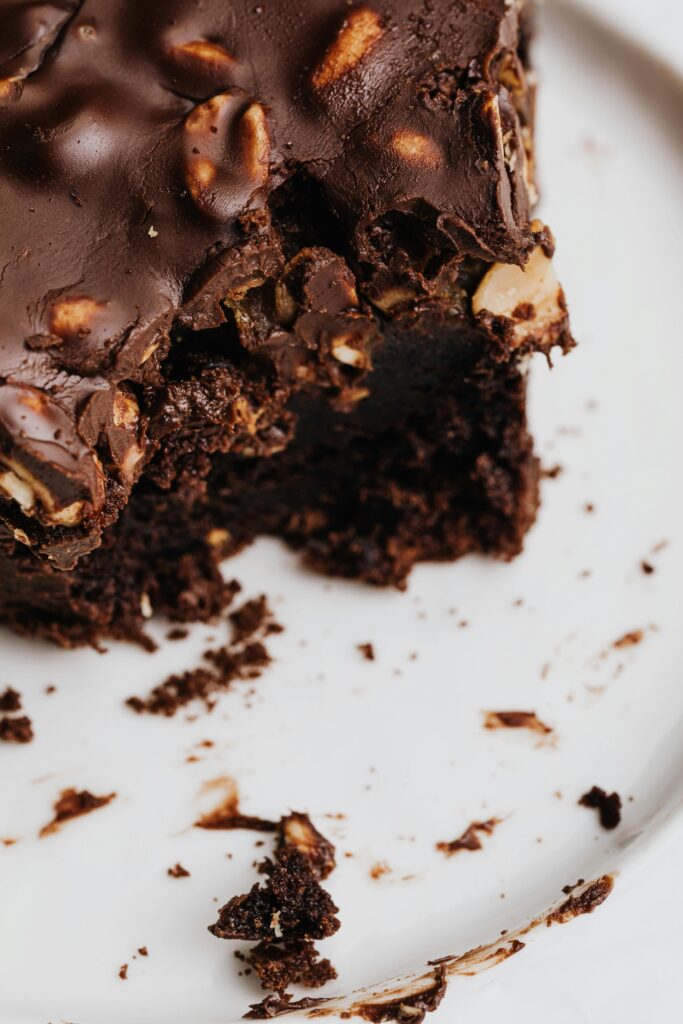 pexels-photo-5386663-5386663 Close-up of a decadent chocolate brownie with nuts on a white plate.