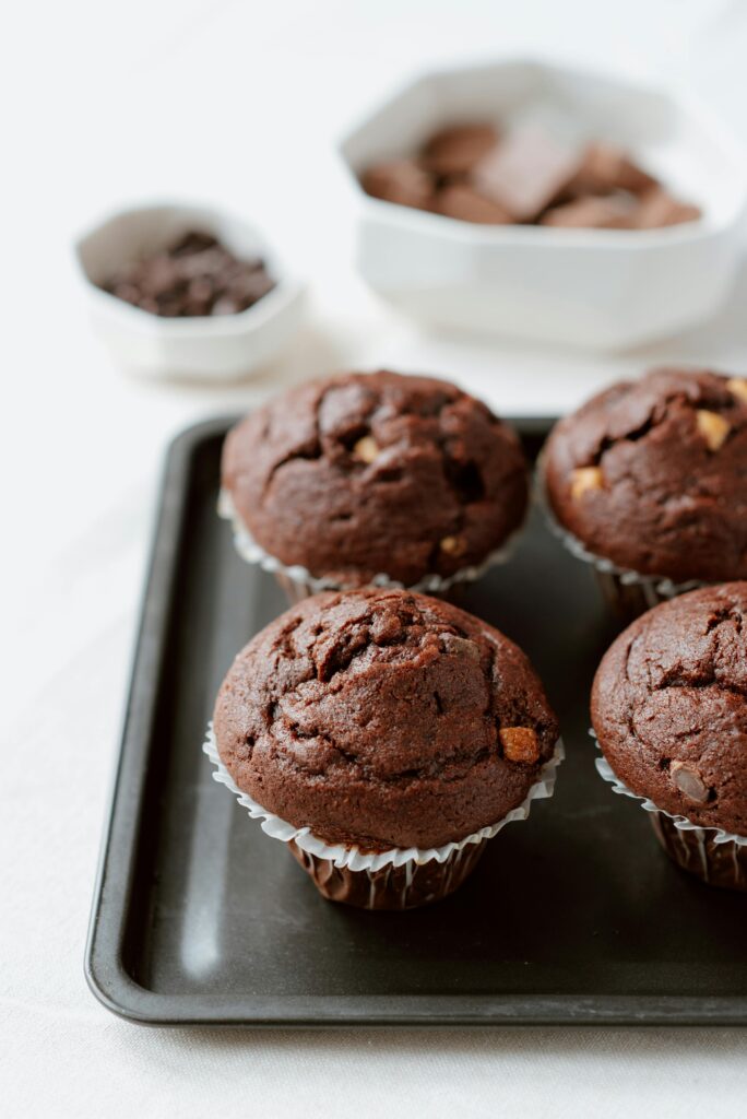 pexels-photo-4792400-4792400 From above of sweet chocolate muffins in white paper cups arranged on tray in kitchen