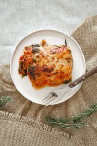 Top view of a classic homemade lasagna served on a rustic plate.