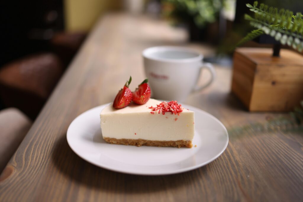 Close-up of a strawberry cheesecake slice on a rustic table, indoors.