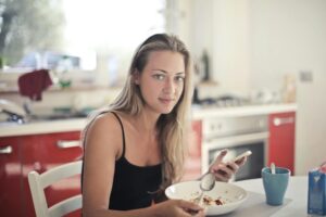 Woman enjoying a healthy breakfast in a modern kitchen, promoting a balanced lifestyle.